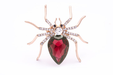 Golden spider with a big red stone isolated on white