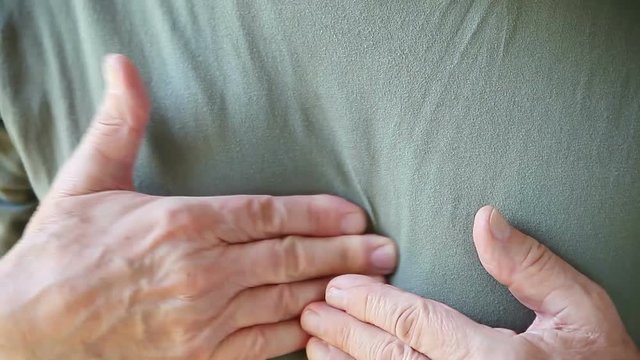 Senior man touches the areas of discomfort in his chest