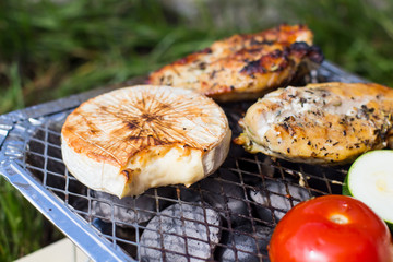 Grill with vegetables. Tomatoes, zucchini, chicken and cucumber. On the grid grill are fried vegetables.