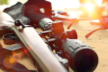 Deurstickers Jacht close-up van geweertelescoop voor sportjacht op houten tafel