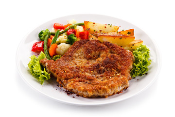 Fried pork chop, baked potatoes and vegetable salad