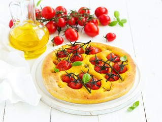 Focaccia of pumpkin dough with tomatoes, rosemary and garlic.