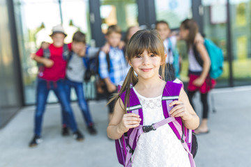 Portrait Of School Pupils Outside Classroom Carrying Bags