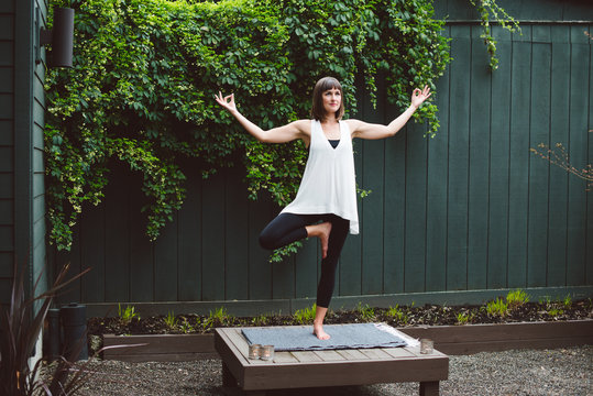 Woman standing in yoga post outside in garden
