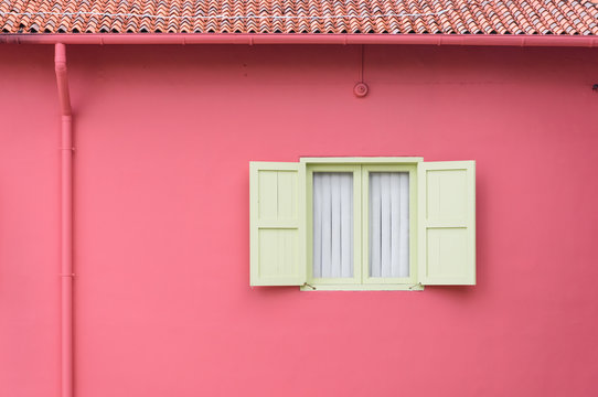 Window on pink wall with shutters