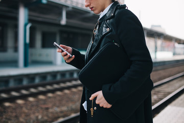 Woman browsing on her mobile phone on train station