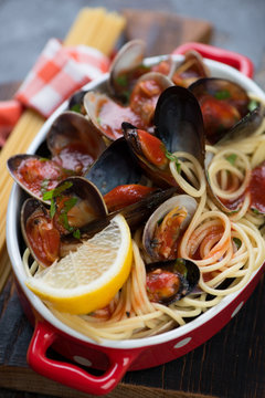 Close-up of spaghetti with vongole shells and mussels in tomato sauce, selective focus, shallow depth of field