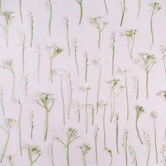 Fototapeta na wymiar Floral pattern made of lily of the valley, green leaves, branches on pink background. Flat lay, top view. Floral pattern. Pattern of flowers. Flowers pattern texture