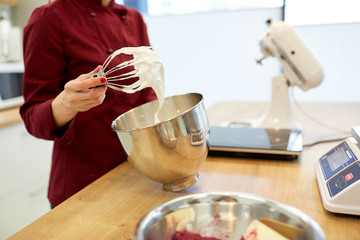 chef with whisk and whipped egg whites at kitchen