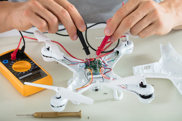 Man Testing Electric Current Of Drone Using Multimeter Tool