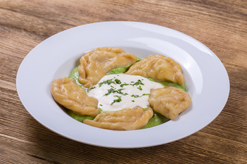 Ukrainian and Russian dish vareniki with mashed potatoes and sour cream. Close up.