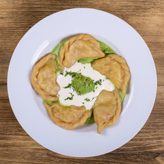 Ukrainian and Russian dish vareniki with mashed potatoes and sour cream. Close up. Top view