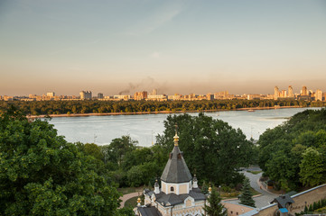 Fototapeta na wymiar Sunset view on Pechersk Lavra Monastery in Kiev, Ukraine. Shot on a summer evening with no people in the shot. River Dniepr and Left Coast of Kiev city is visible in the background