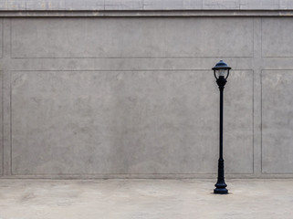 The lamp on the footpath and the wall in the dim atmosphere.