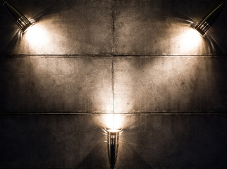 Trois lampes sur un mur sombre la nuit