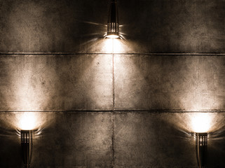 Hintergrundbild einer dunklen Wand mit drei Lampen darüber