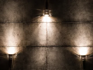 Foto op Plexiglas Licht en schaduw Achtergrondafbeelding van een donkere muur met drie lampen erboven