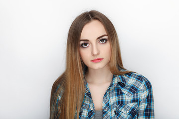 Beauty portrait of young adorable fresh looking blonde woman with hair chaos in blue plaid shirt. Emotion and facial expression concept.