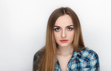 Beauty portrait of young adorable fresh looking blonde woman with hair chaos in blue plaid shirt. Emotion and facial expression concept.