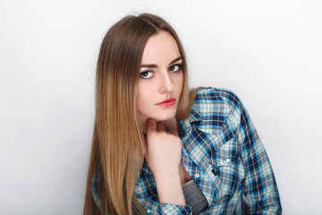 Beauty portrait of young adorable fresh looking blonde woman with hair chaos in blue plaid shirt. Emotion and facial expression concept.