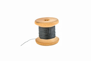 Wooden spool with black thread on a white background