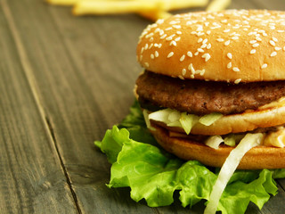 Hamburger and fries on a wooden cutting board