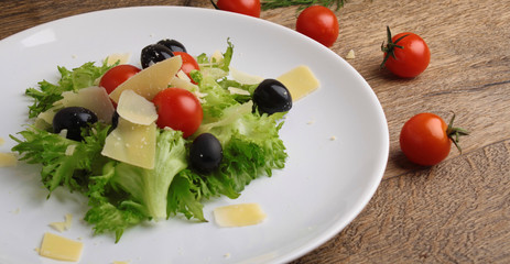 Fresh vegetables salad with tomatoes , olives , parmesan cheese