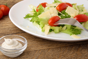 Fresh salad parmesan on a wooden background