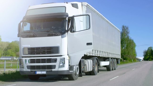 Truck Driver Gets out of His Parked White Cab-Over Truck. Day is Sunny, Driver is Professional. Shot on RED EPIC-W 8K Helium Cinema Camera.
