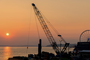 Fototapeta premium Seaside construction crane at sunset