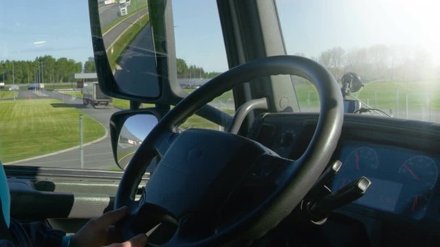 Inside of Cabin View of the Professional Truck Driver Driving His Big  Vehicle on the Road. Industrial Warehouses are Seen out of the Window. Shot on RED EPIC-W 8K Helium Cinema Camera.