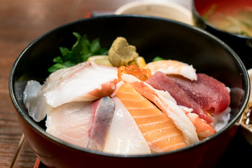 Japanese food with raw fishes, called sashimi on the rice in Bowl in Hakodate morning market, Hokkaido, Japan.
