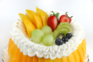 colorful fruit birthday cake isolated on white background