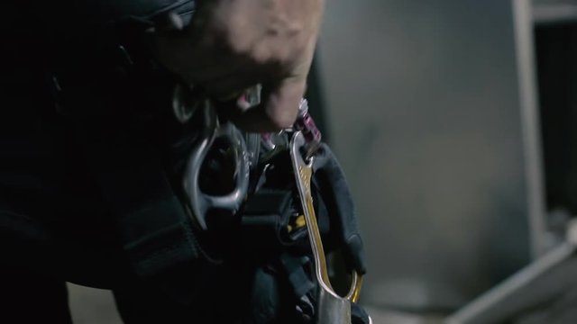 Climber uncouples and clings the hooks on his outfit