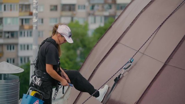 Woman climber checks the safety of the outfit