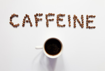 Letter of CAFFEINE arranged with coffee beans on white background with some space for your text