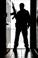 Intruder at door, in silhouette with AR-15 style long gun