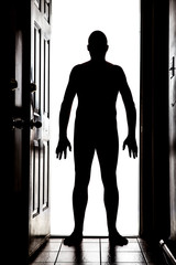 Naked man at door in silhouette