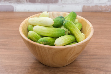 fresh cucumber on  wood bowl