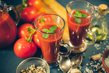 Red tomatoes, juice and spices on dark background. Tomato juice. Close up. Selective focus. Low-key lighting