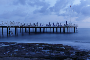 Seascape with pier and rocky shore