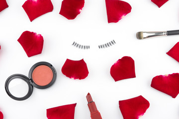 Cosmetics decorated with red rose petals on white background