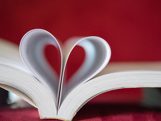 Closeup soft focus pages of a book curved into a heart shape. Love and Valentine's day concept.