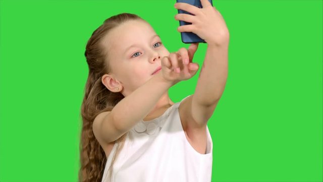 Little cute girl smile and taking selfie on a Green Screen, Chroma Key