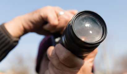 A large lens in the camera of a man