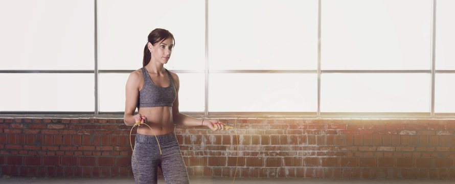 Woman Doing Exercises With Jump Rope In Front Of Window