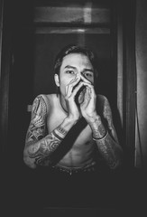 A man sitting at the door with both arms in a tattoo