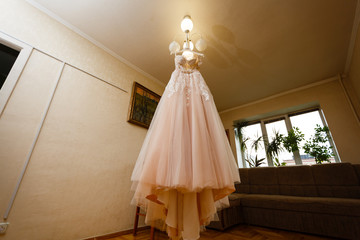 Pink wedding dress hangs from the chandelier