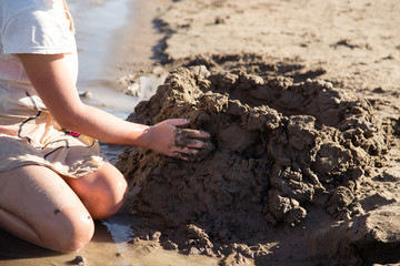 Girl playing in the sand on the lake