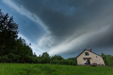 Scarry dark storm clouds over forest and house